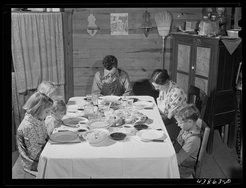 Smith family saying grace at the afternoon meal. Carroll County, Georgia (see general caption). Sourced from the Library of…