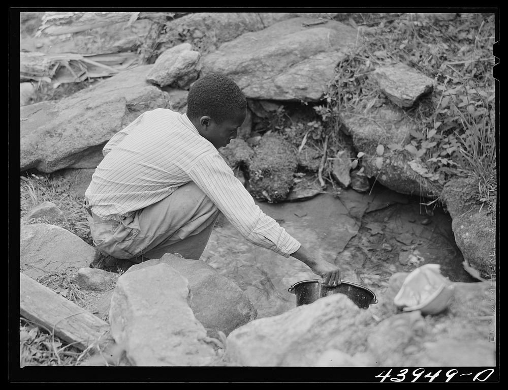 Son of Mr. Frank Cunningham, FSA (Farm Security Administration) borrower, gets some water from the spring, the only source…