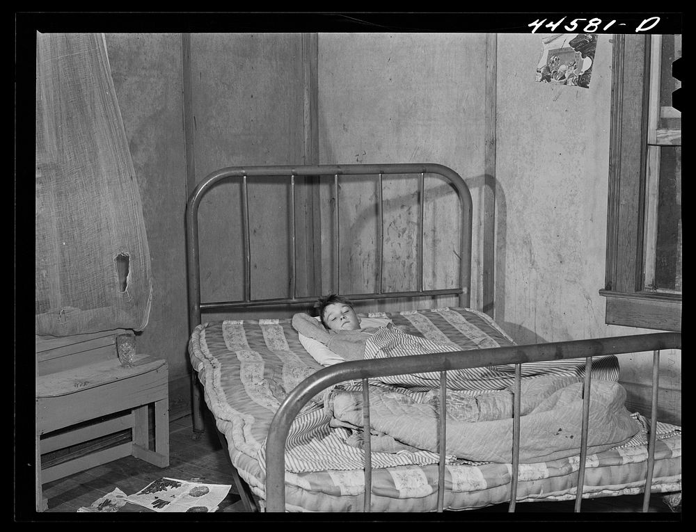 Young boy in bed with measles in the home of a FSA (Farm Security Administration) borrower. Greene County, Georgia. Sourced…