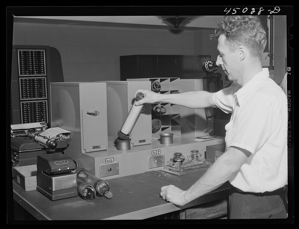 Sending the weather data down thru the compressed air tube from the teletype room. Washington, D.C. municipal airport.…