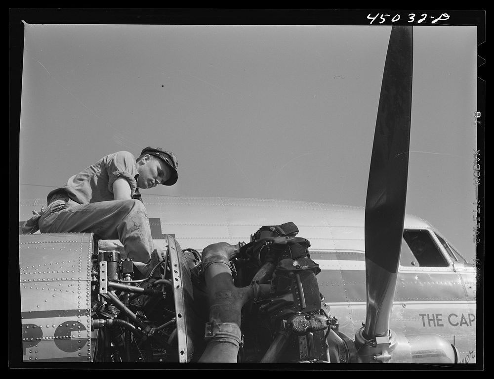 Working on an engine of one of the airliners. Washington, D.C. municipal airport. Sourced from the Library of Congress.