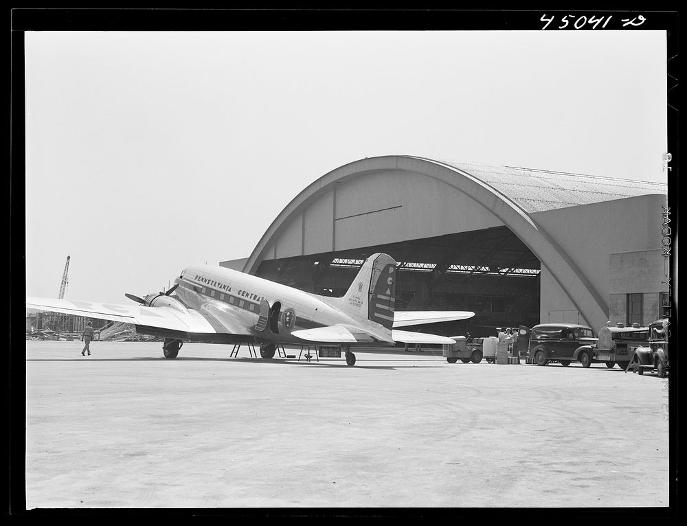 A plane in front of the huge hangar. Municipal airport, Washington, D.C.. Sourced from the Library of Congress.