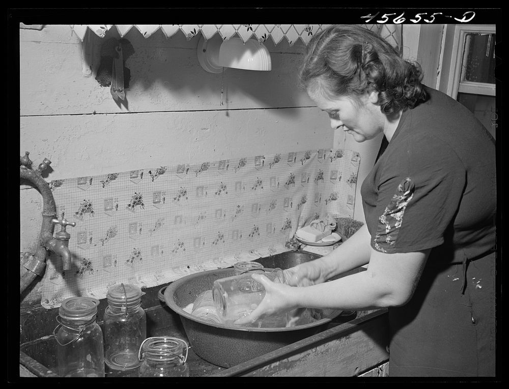 Mrs. William Gaynor washing jars, preparing to can on their farm near Fairfield, Vermont. Sourced from the Library of…