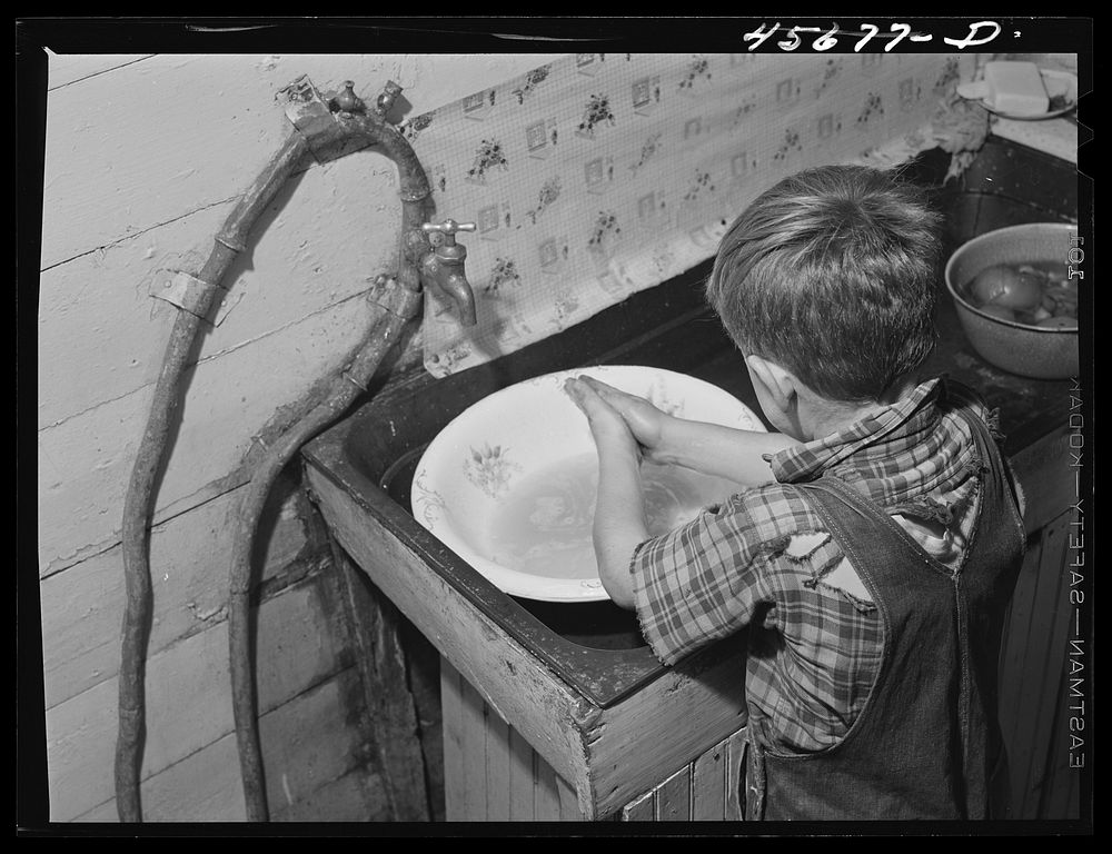 Dicky Gaynor washing his hands on their farm near Fairfield, Vermont. Sourced from the Library of Congress.