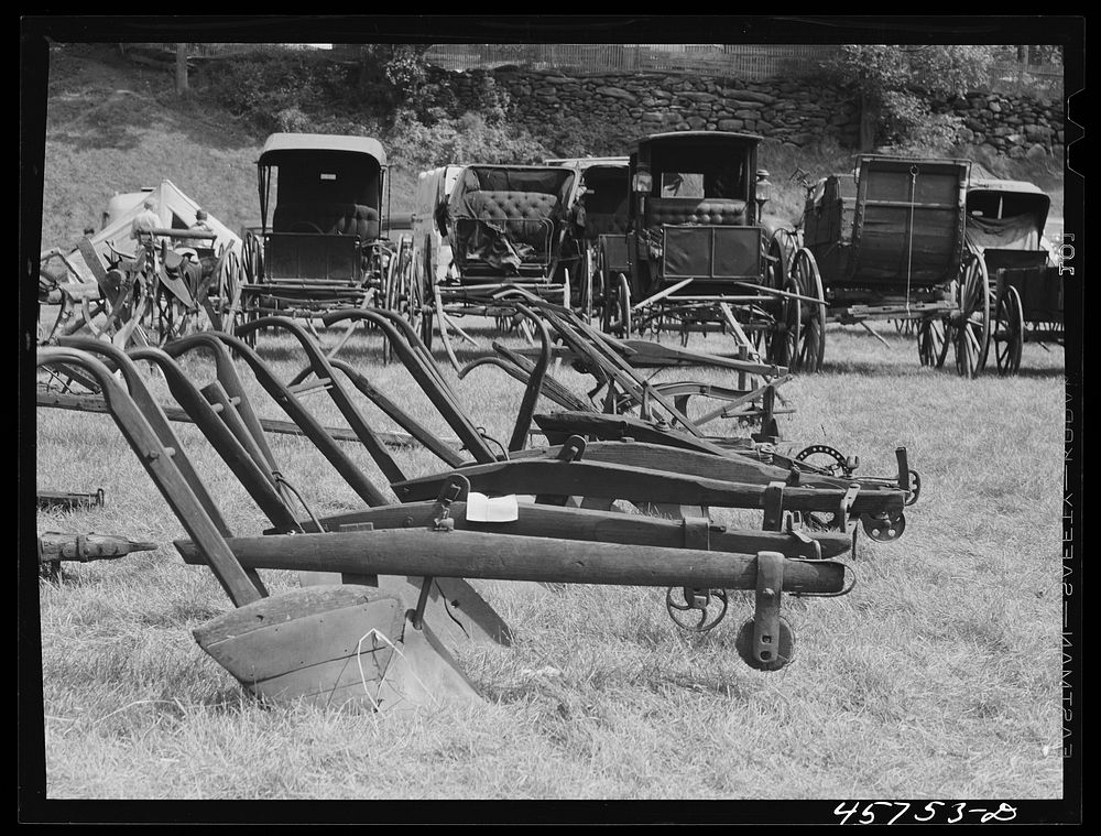 Exhibit of old ploughs and antique buggies at the World's Fair at Tunbridge, Vermont. Sourced from the Library of Congress.