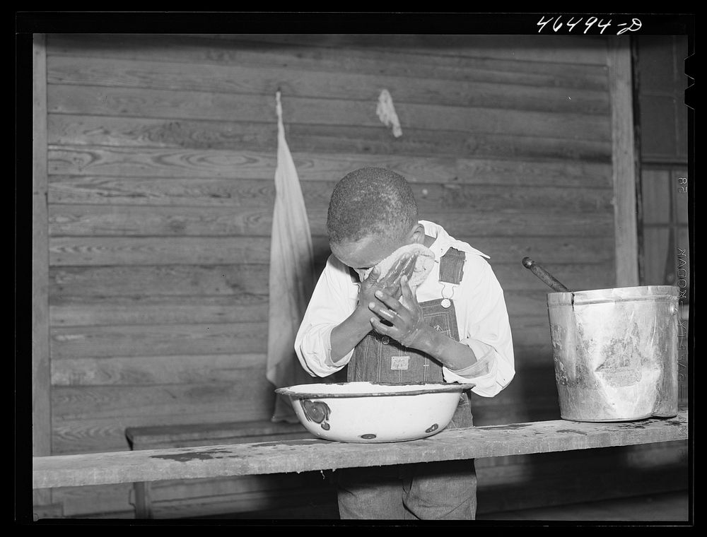 Boyd Jones washing his face on the back porch of his house, Greene County, Georgia. Sourced from the Library of Congress.
