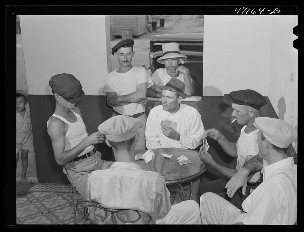 French Village, a small settlement on Saint Thomas Island, Virgin Islands. A group of card players in the one tavern and…