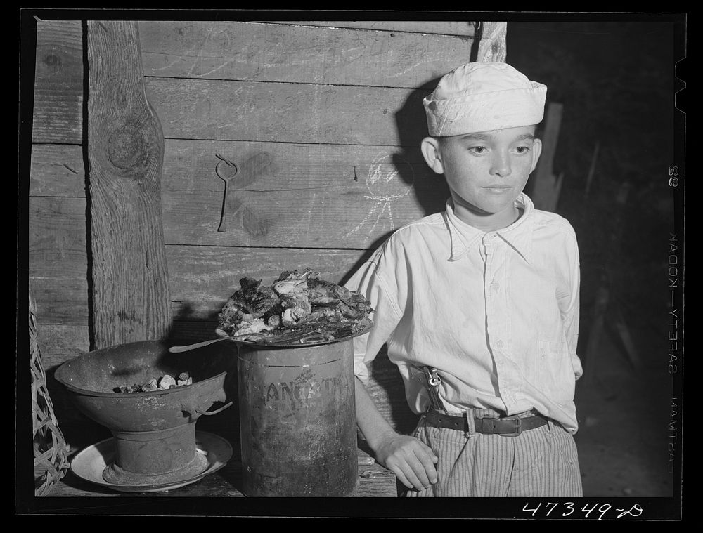 French village, a small settlement on Saint Thomas Island, Virgin Islands. Child of a French family with supper of fried…