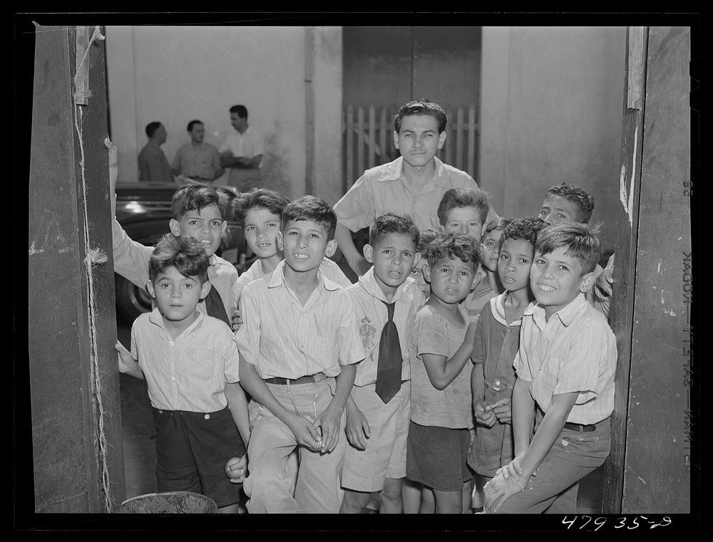 Yauco, Puerto Rico. Children crowding around to watch the photographer. Sourced from the Library of Congress.