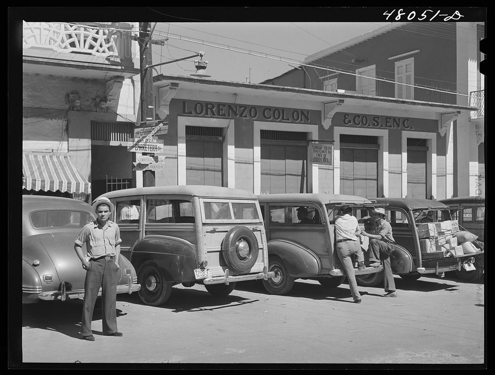 [Untitled photo, possibly related to: Arecibo, Puerto Rico. A row of station wagons or "publicos" waiting for loads and…