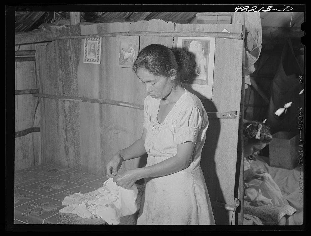 Utuado, Puerto Rico (vicinity). Farm woman doing needlework under contract to a factory in town. Sourced from the Library of…