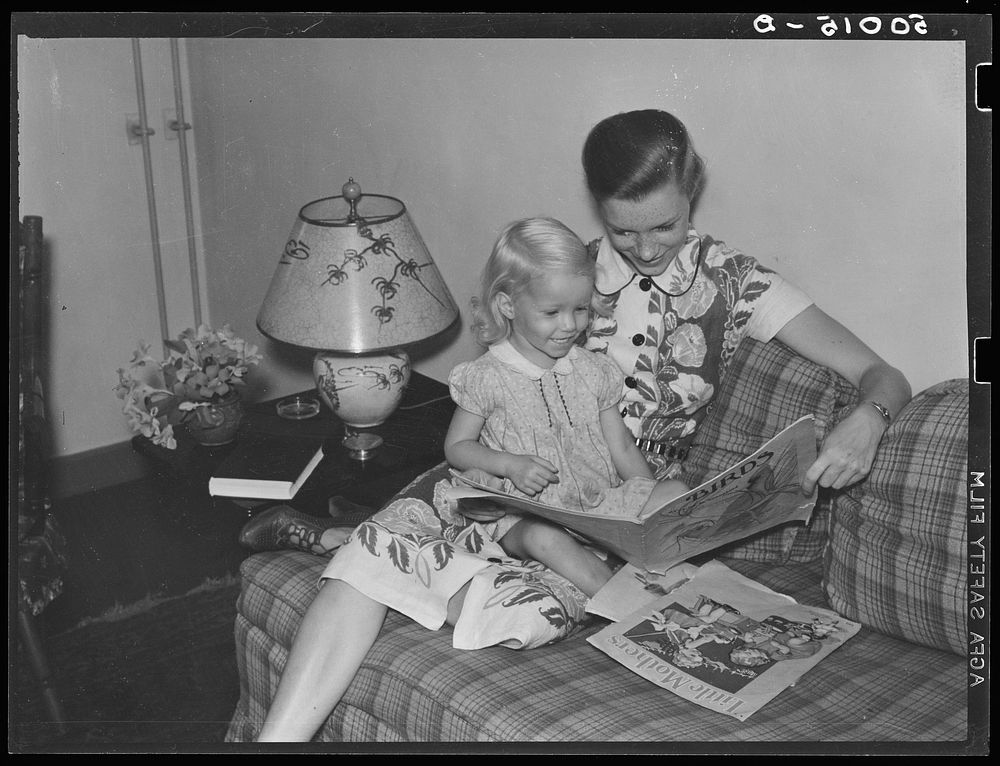 Mrs. Betty Zimmerman and her child in living room of their new home. Greenbelt, Maryland. Sourced from the Library of…