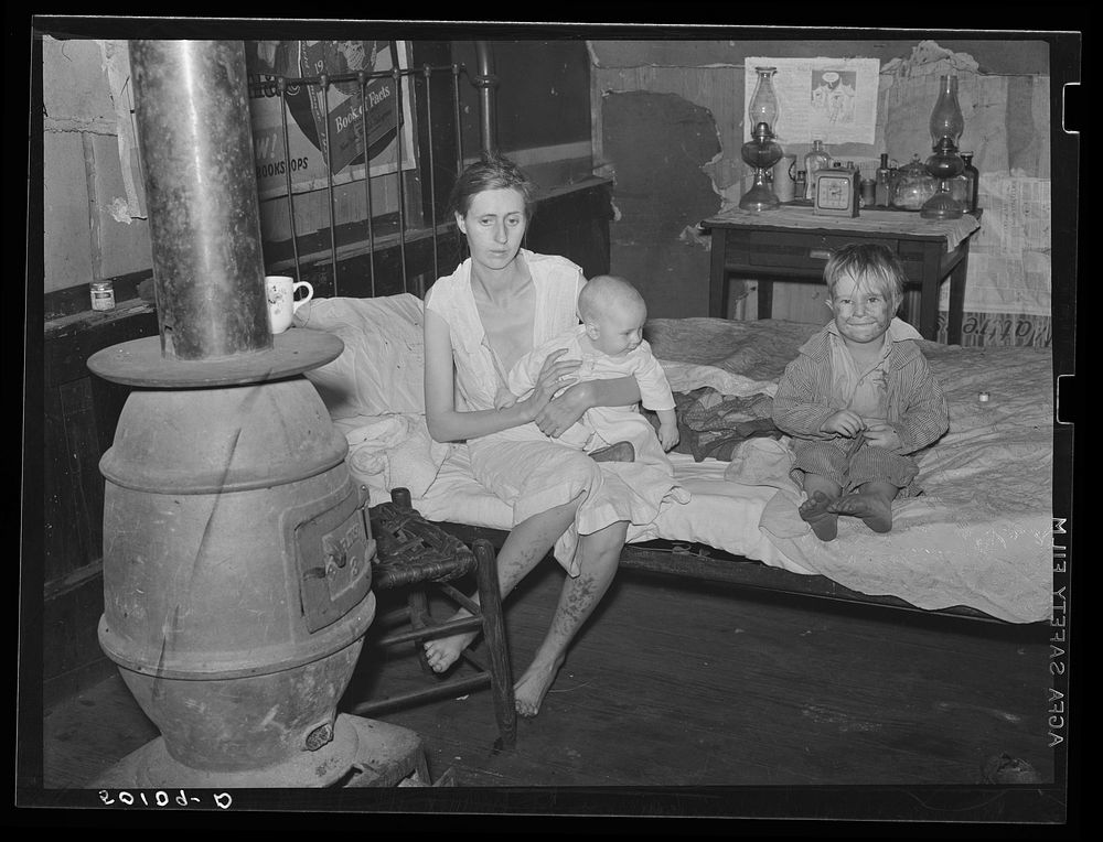 Wife and two children of unemployed mine worker. She has TB and syphilis. They are one of five families living in old…