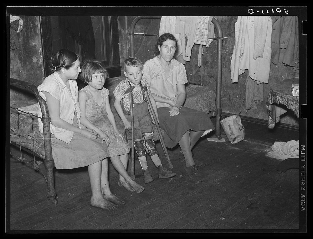 Part of one family living in miner's boarding house. One woman and six children live in one room. Two beds, no water, no…