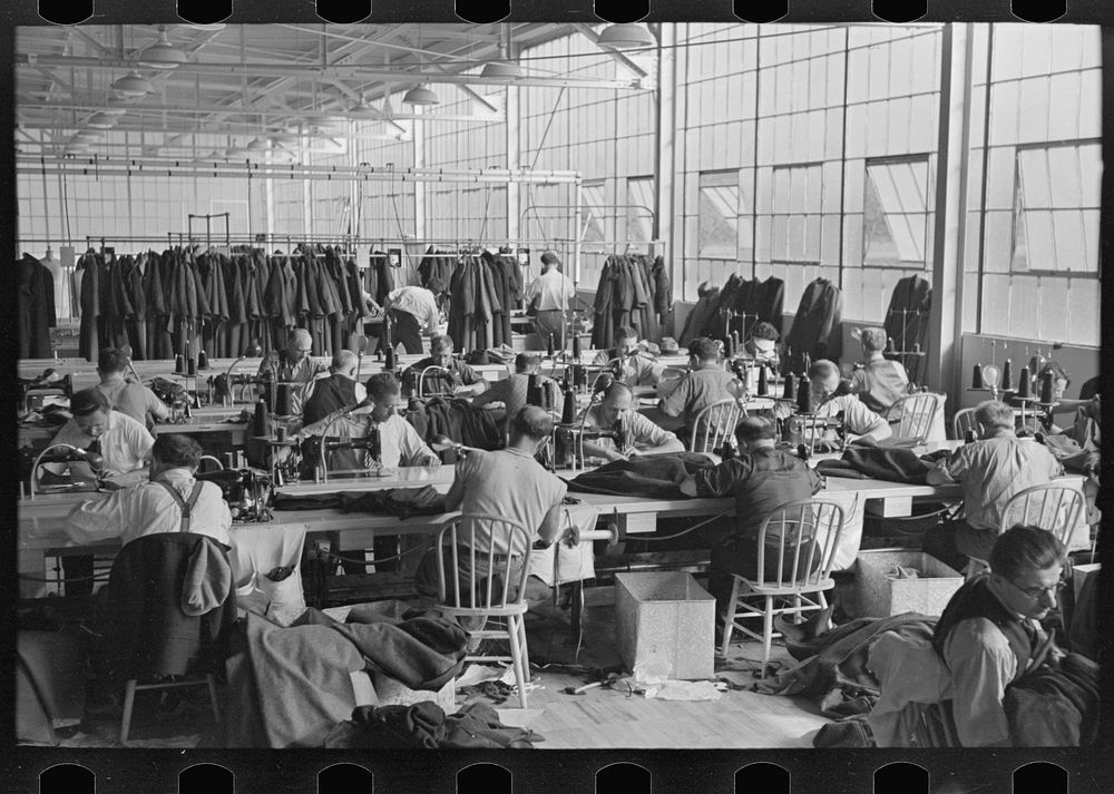 Interior of cooperative garment factory at Jersey Homesteads, showing some of the eighty homesteaders at their work and some…