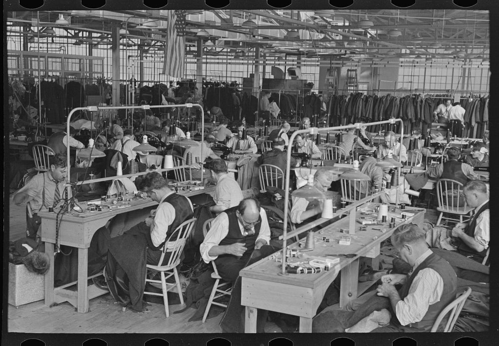 Interior of cooperative garment factory at Jersey Homesteads, showing some of eighty homesteaders at their work and some of…