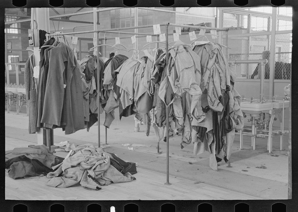 [Untitled photo, possibly related to: Half-made garments on the racks, awaiting final operations of the machines, in…