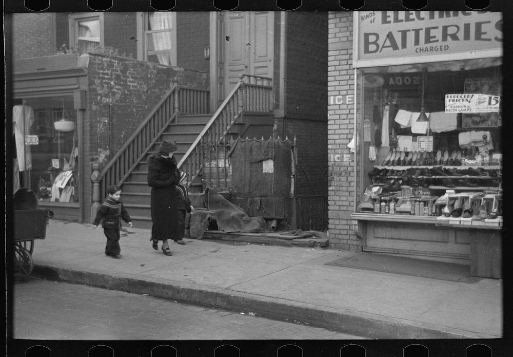 [Untitled photo, possibly related to: Mothers talking together and child playing in the gutter, 139th Street just east of…
