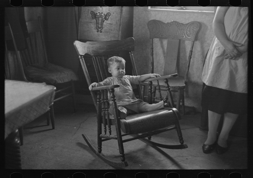 One of L.H. Nissen's children in rocking chair. Nissen shack near Dickens, Iowa. Nissen is a hired man by Russell Lee