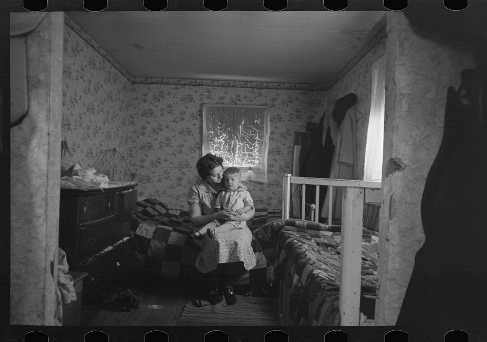 Mother and child in another bedroom of the Nissen shack near Dickens, Iowa by Russell Lee