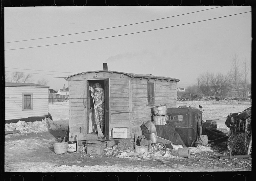 Mrs. Charles Benning sweeping steps of shack in "Shantytown," Spencer, Iowa by Russell Lee