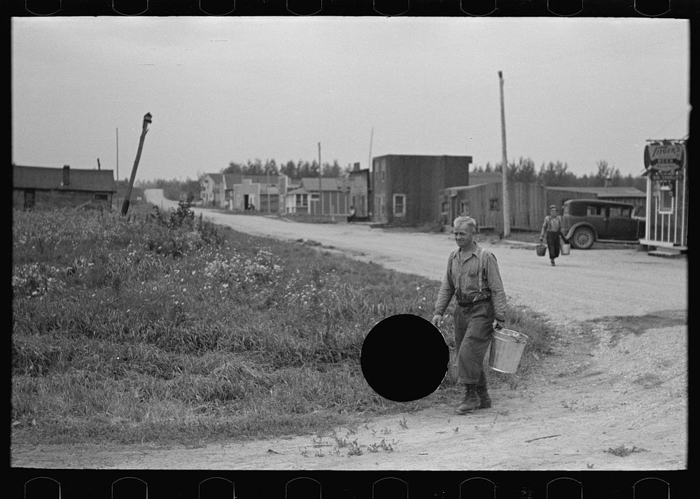 [Untitled photo, possibly related to: Herman Gerling dipping water from a spring to fill the barrels on his truck. North…