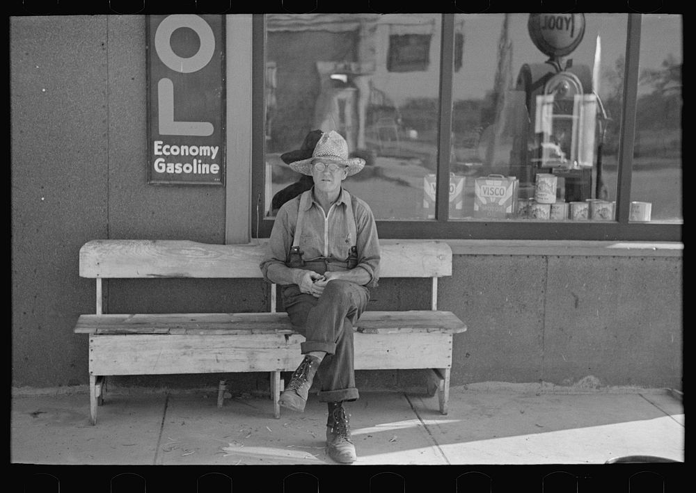 Man sitting in front of store, Craigville, Minnesota by Russell Lee