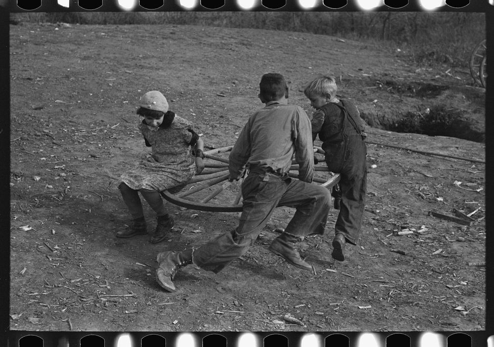 Farm children playing on homemade merry-go-round. Williams County, North Dakota by Russell Lee