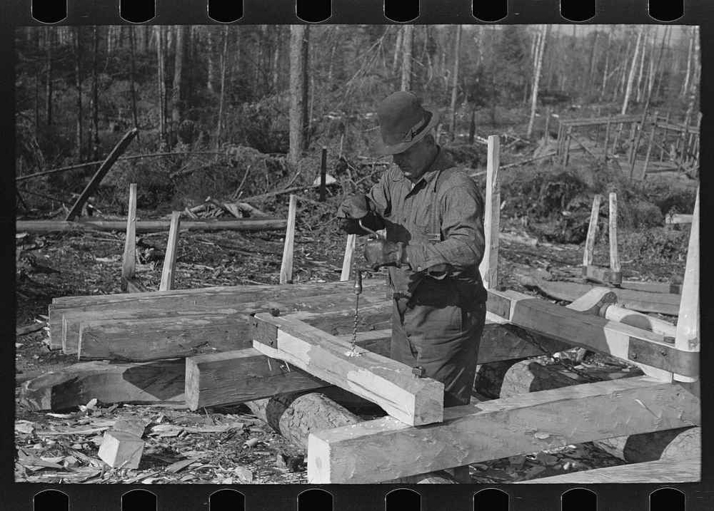 [Untitled photo, possibly related to: Drilling hole in construction of sleds for hauling timber at camp near Effie…