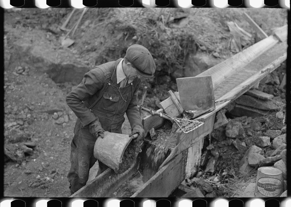 [Untitled photo, possibly related to: Gold miner at work in sluice box, Two Bit Creek, South Dakota] by Russell Lee