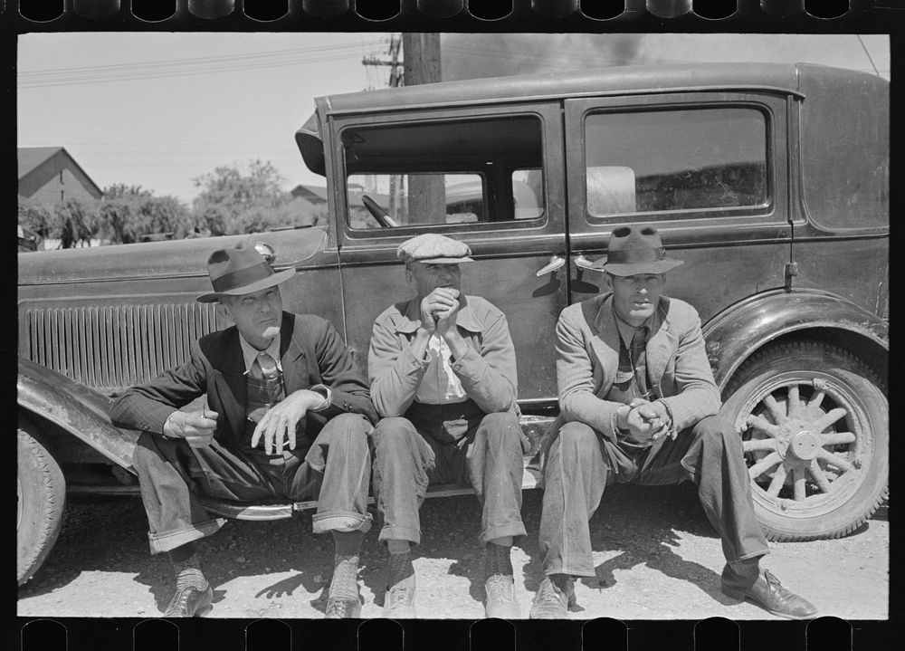 Farmers sitting on running board of car at liquid feed loading station, Owensboro, Kentucky by Russell Lee