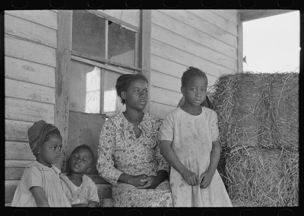 [Untitled photo, possibly related to: Part of sharecropper family on porch of cabin. Note the absence of storage space] by…