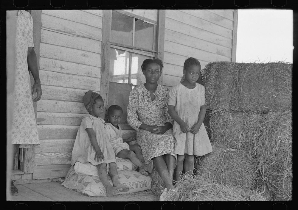 Part of sharecropper family on porch of cabin. Note the absence of storage space by Russell Lee