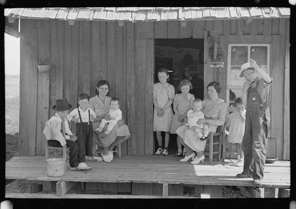 [Untitled photo, possibly related to: Sharecropper family on front porch of cabin, New Madrid County, Missouri] by Russell…