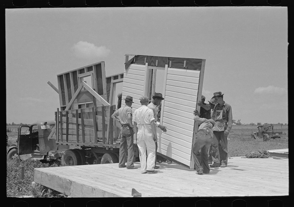 House erection. Unloading panels onto the platform. Southeast Missouri Farms Project by Russell Lee