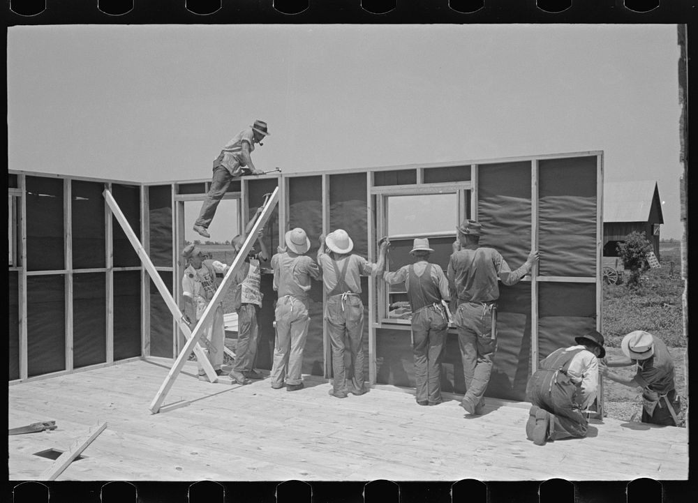 Southeast Missouri Farms Project. House erection. Panels are moved into place around circumference and nailed by Russell Lee