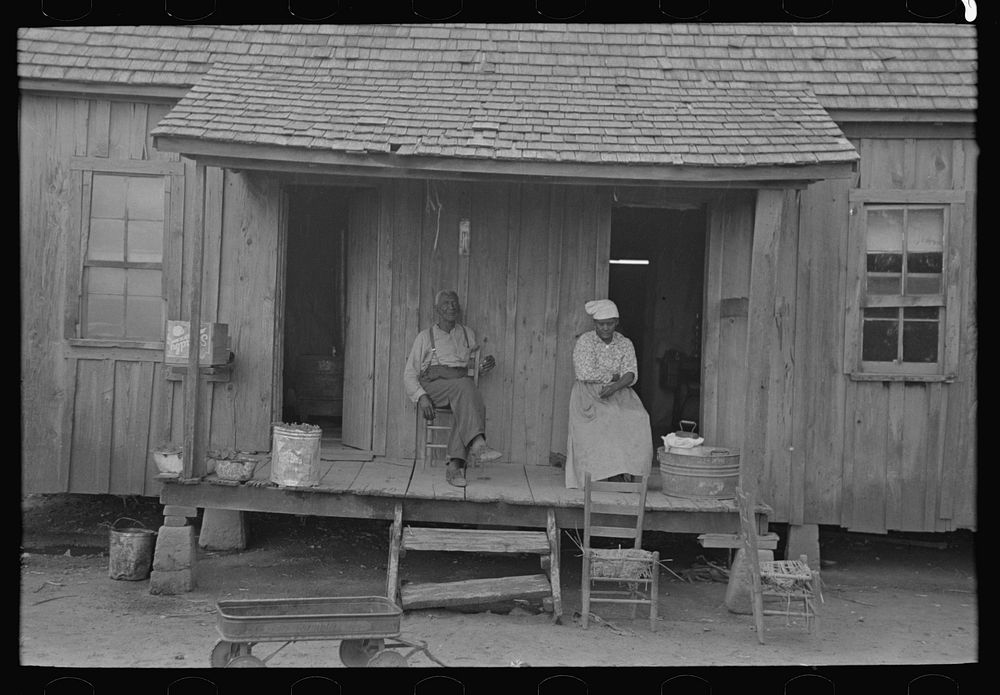 Old  couple sitting on front porch of shack home, Southeast Missouri Farms by Russell Lee