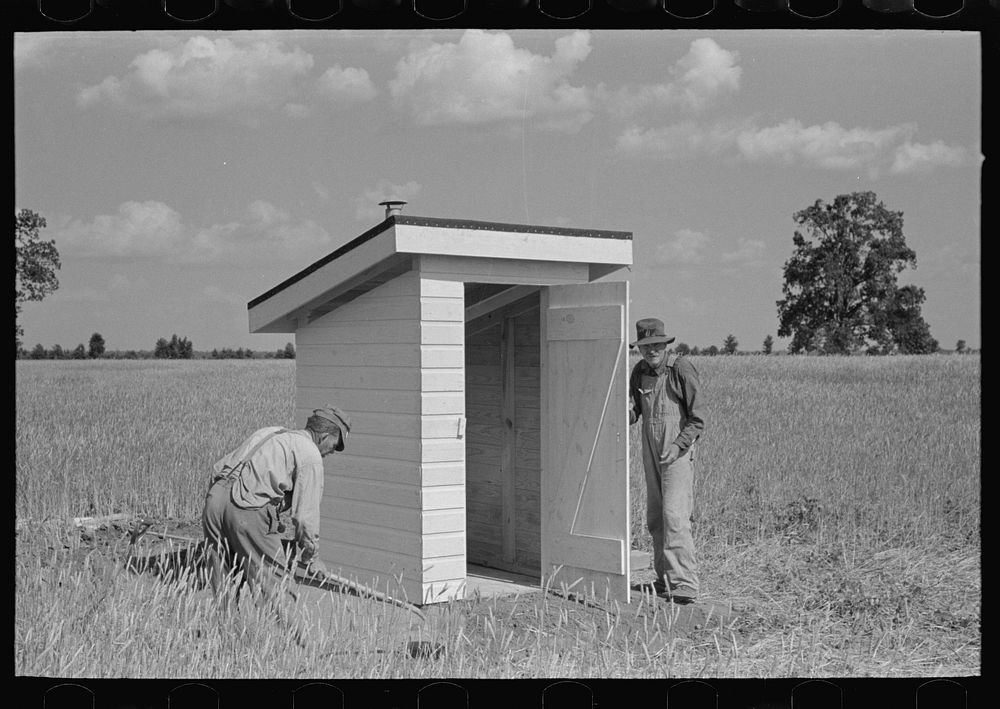 [Untitled photo, possibly related to: Southeast Missouri Farms Project. Final operation in setting of sanitary privy at the…