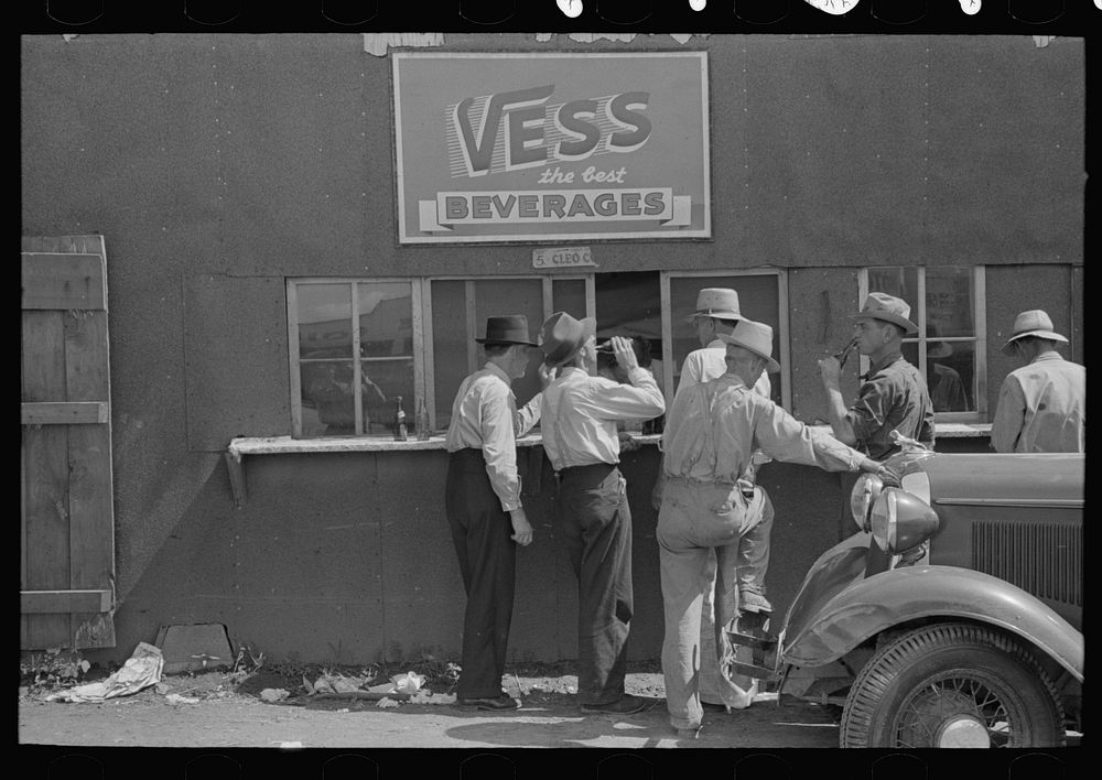 Farmers at auction with soft drinks, Sikeston, Missouri by Russell Lee