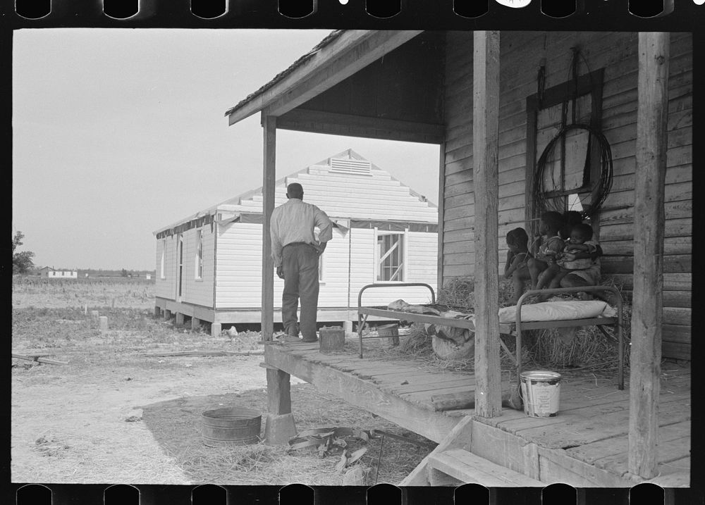 FSA (Farm Security Administration) client and family, former sharecroppers, looking at new home from porch of old shack…