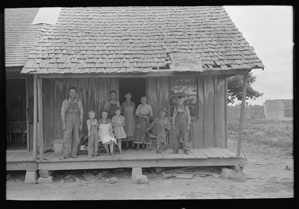 Sharecropper family on front porch of cabin, Southeast Missouri Farms by Russell Lee