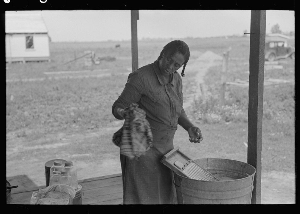[Untitled photo, possibly related to: Wife of sharecropper washing clothes, Southeast Missouri Farms] by Russell Lee