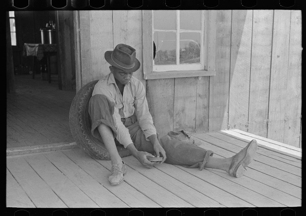 [Untitled photo, possibly related to: Son of sharecropper on front porch of shack home, Southeast Missouri Farms] by Russell…