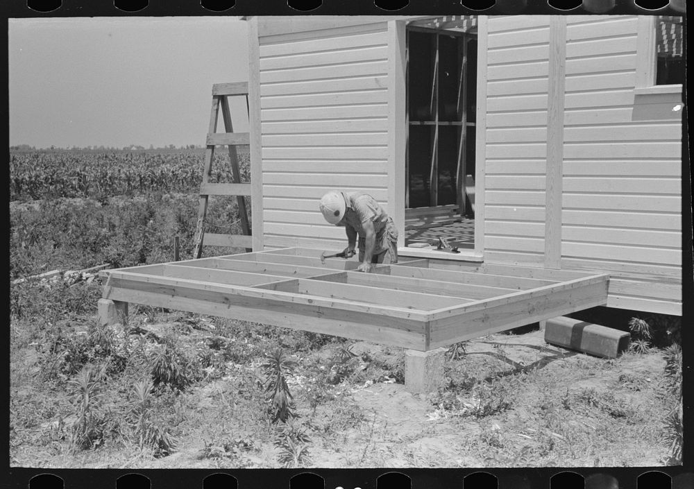 [Untitled photo, possibly related to: Southeast Missour Farms Project. House erection.  Shop-assembled porch floor being…