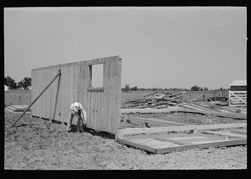 Barn erection. Outside panels are raised into place and secured. Note distribution of panels around the sills. Southeast…