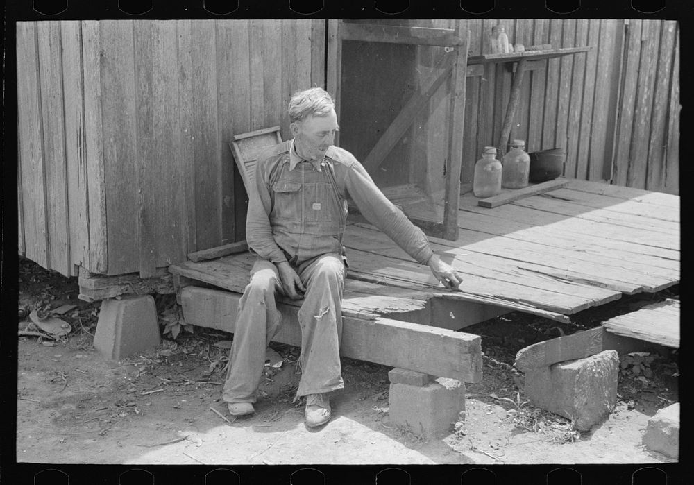Farmer sitting on rotted porch of his old home, Southeast Missouri farms by Russell Lee