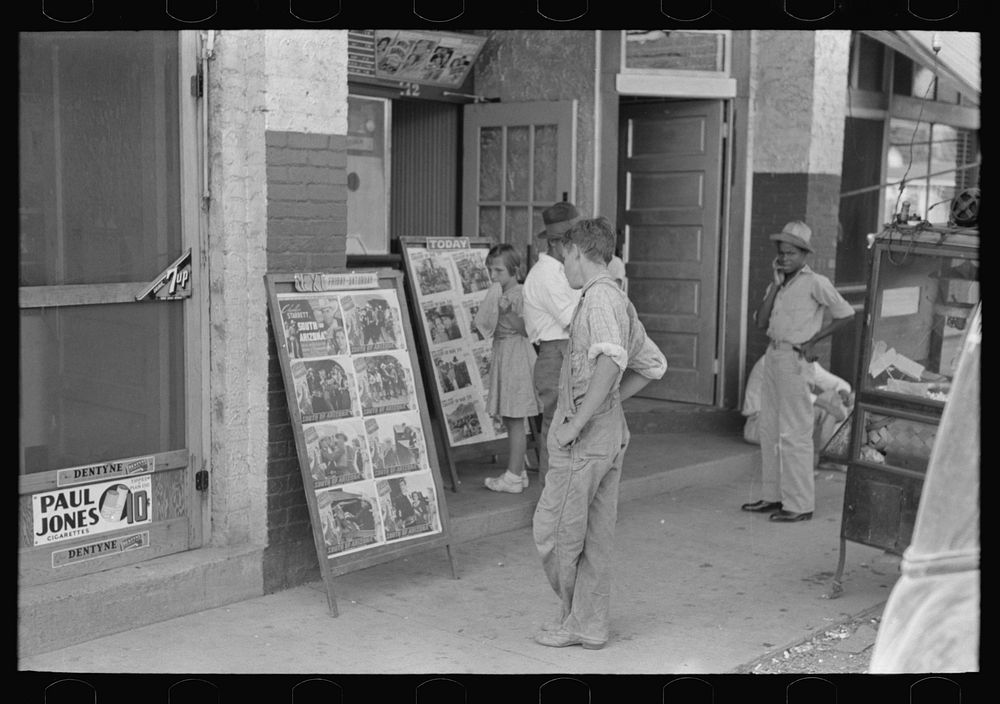Children looking at posters in front of movie, Saturday, Steele, Missouri by Russell Lee