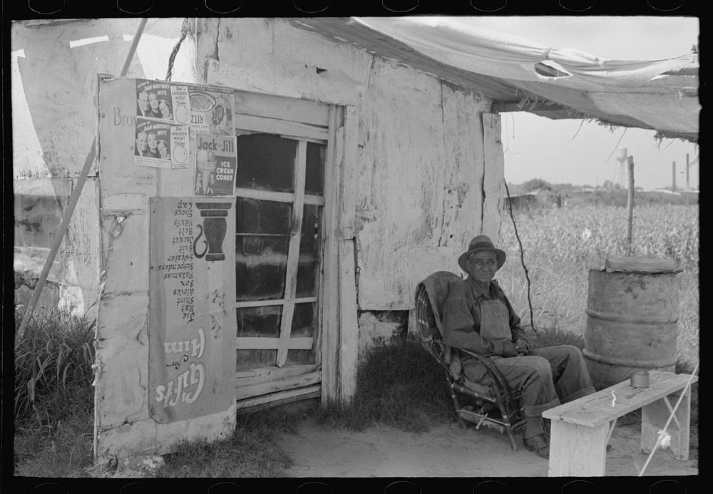 Resident of "Tin Town" sitting in front of his shack home, Caruthersville, Missouri by Russell Lee