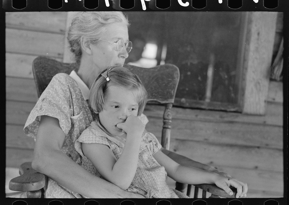 Background photo. Wife of FSA (Farm Security Administration) client with daughter. They will participate in tenant purchase…