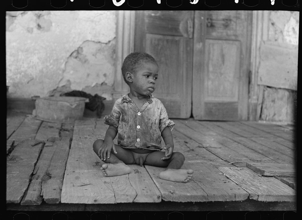 Child on porch of dilapidated Trepagnier plantation near Norco, Louisiana by Russell Lee